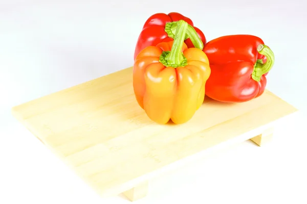 Świeże i soczyste warzywa na płytce drewna na białym tle — Zdjęcie stockowe