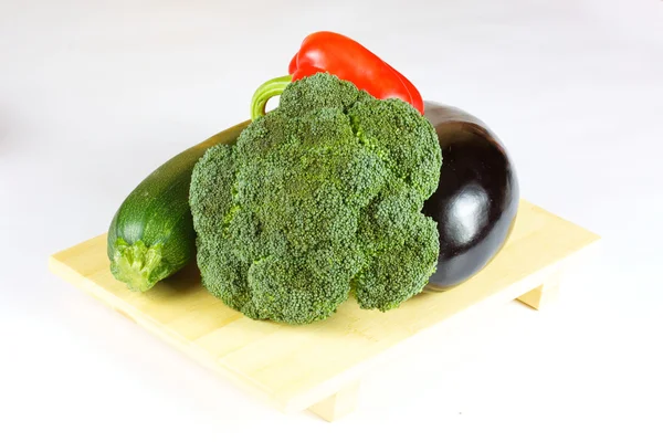Verduras frescas y jugosas en el plato de madera aisladas —  Fotos de Stock