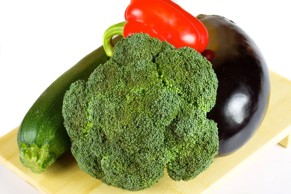 Čerstvé a šťavnaté zeleniny na dřevěné desce izolované — Stock fotografie