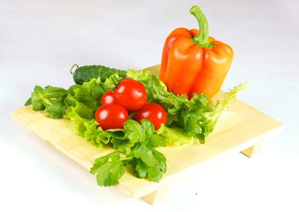 Légumes frais et juteux sur la plaque de bois isolé — Photo