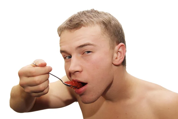 Genç adam yeme kırmızı havyar — Stok fotoğraf