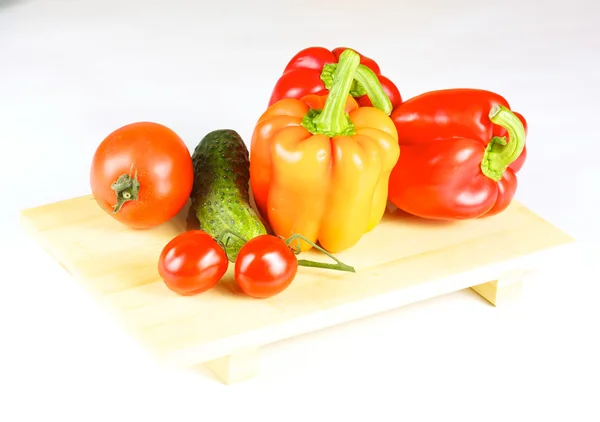Fresh and juicy vegetables on the wood plate isolated — Stock Photo, Image