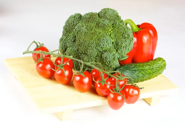 Verduras frescas y jugosas en el plato de madera aisladas —  Fotos de Stock