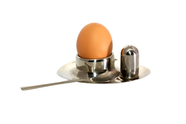 Ägg i äggkoppar på en bricka med saltshaker isolerade över vita — Stockfoto