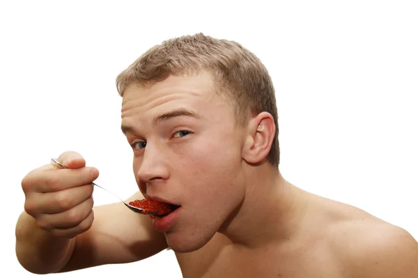 Young man eating red caviar — Stock Photo, Image