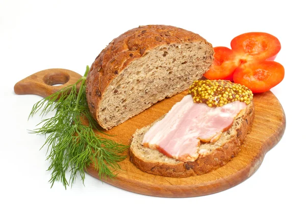 stock image Bread with ham, mustard, dill and tomato on the wood plate