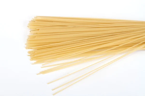 Неприготовленная лапша-спагетти на белом фоне — стоковое фото