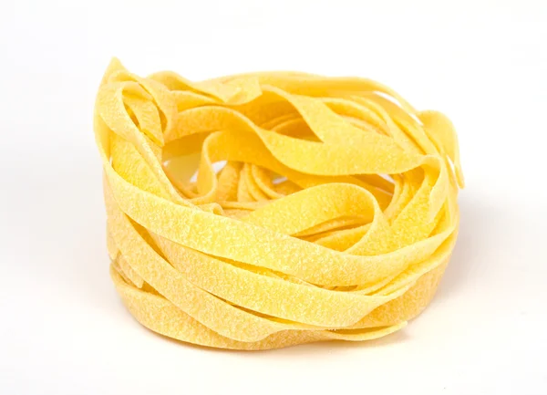Купа сирих сухих макаронних виробів на білому тлі — стокове фото