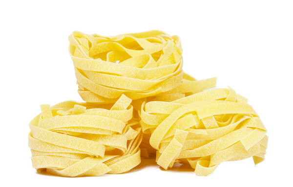 Heap of raw dry nest pasta over white background