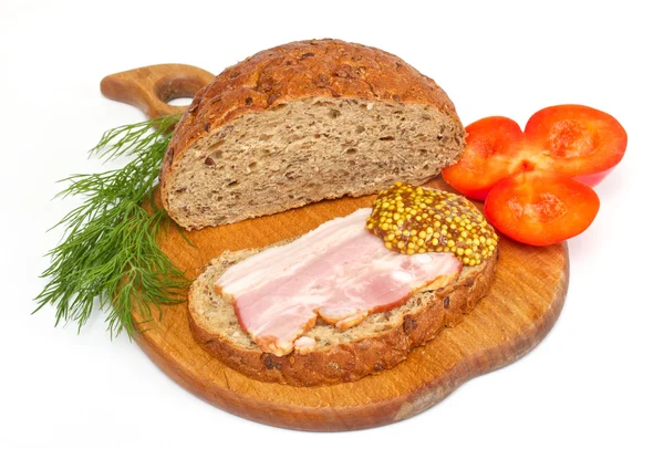 stock image Bread with ham, mustard, dill and tomato on the wood plate