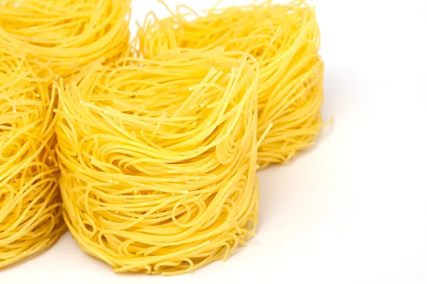 Högen av rå torr kapsla pasta över vit bakgrund — Stockfoto