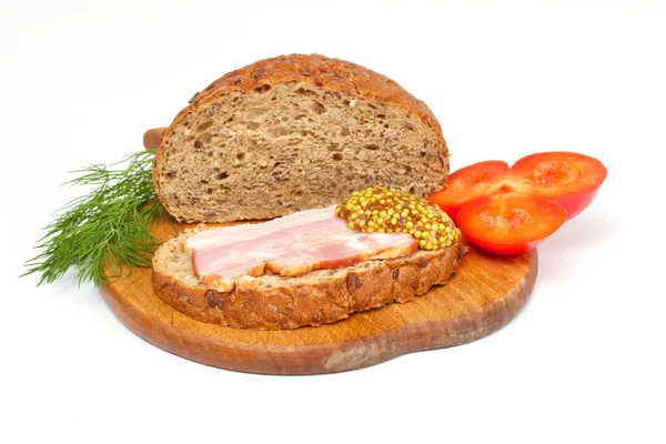 stock image Bread with ham, mustard, dill and tomato on the wood plate
