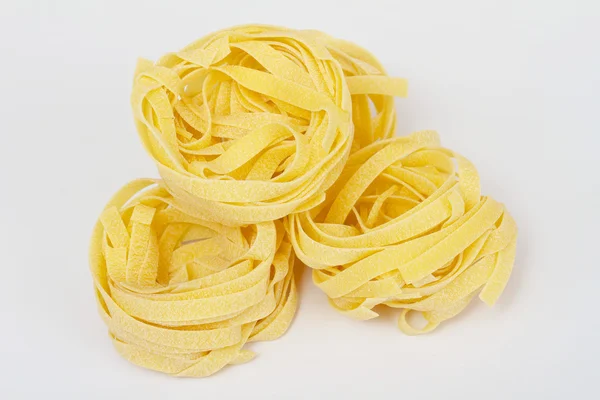 Högen av rå torr kapsla pasta över vit bakgrund — Stockfoto