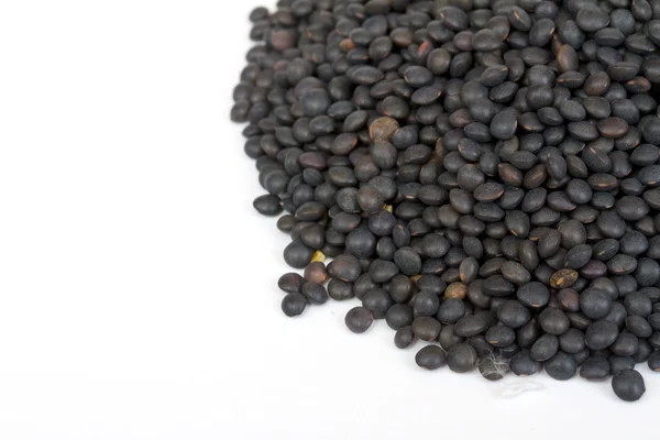 白で隔離される黒いレンズ豆のヒープ — ストック写真