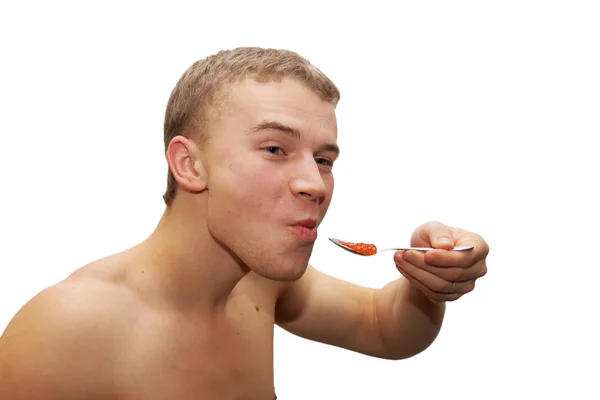 Hombre joven comiendo caviar rojo — Foto de Stock