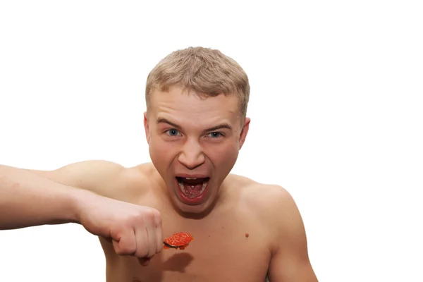 Young man eating red caviar — Stock Photo, Image