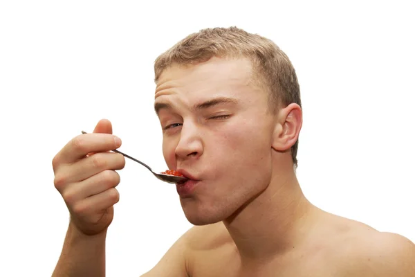 年轻男子吃红鱼子酱 — 图库照片