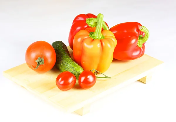 Légumes frais et juteux sur la plaque de bois isolé — Photo