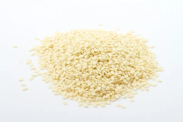 Zamknięcie się na stertę suszone nasiona sezamu na białym tle — Zdjęcie stockowe