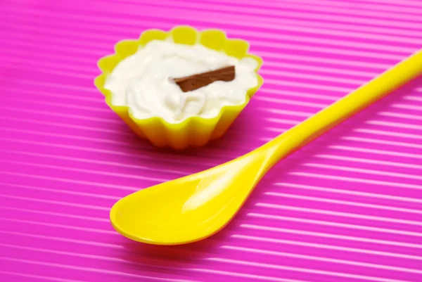 Yellow spoon and portion of whipped cream — Stock Photo, Image