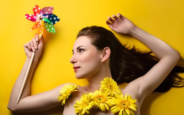 Jonge vrouw met bloemen hou pin wiel — Stockfoto