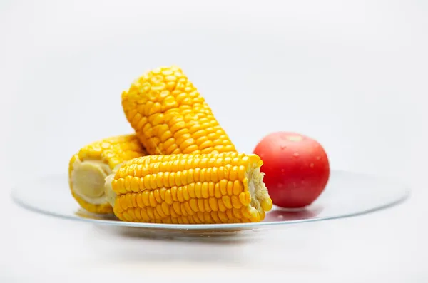 Pollitos de maíz y tomate en un plato de vidrio. Pequeño DOF —  Fotos de Stock