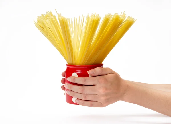 Женские руки держат красную банку со спагетти внутри — стоковое фото