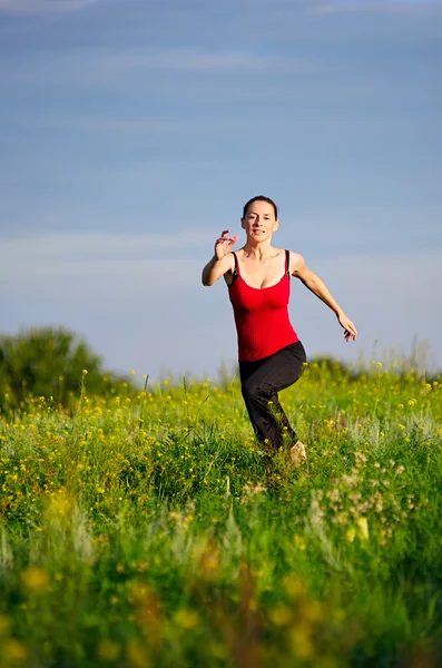 Donna che corre su un campo al tramonto — Foto Stock