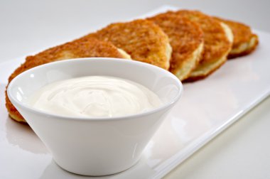 Potato pancakes with sour cream clipart