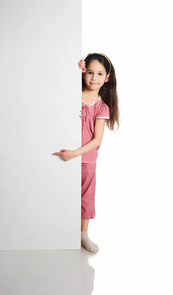 Criança atrás de uma prancha branca — Fotografia de Stock