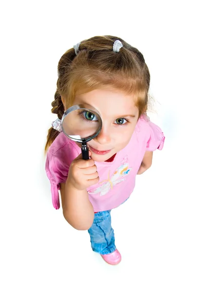 Маленькая девочка смотрит через лупу — стоковое фото