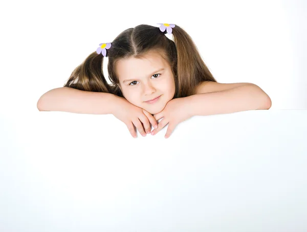 Criança bonito atrás de uma tábua branca — Fotografia de Stock