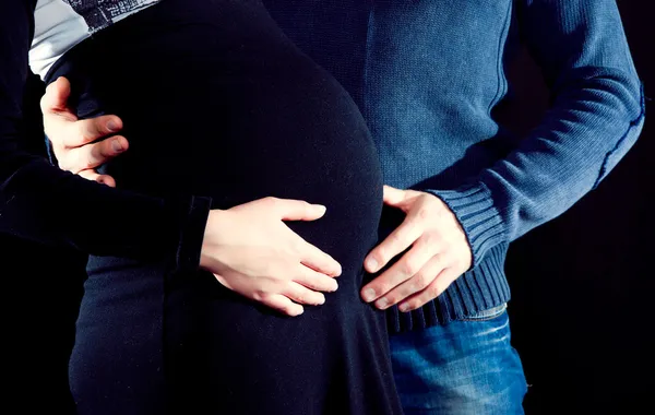 Donna incinta e suo marito si accarezzano la pancia — Foto Stock