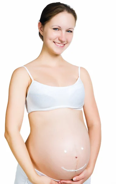 Femme enceinte avec crème cosmétique sur le ventre — Photo