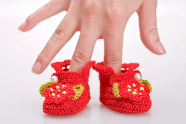 stock image Crocheted booties for a girl in the woman hand