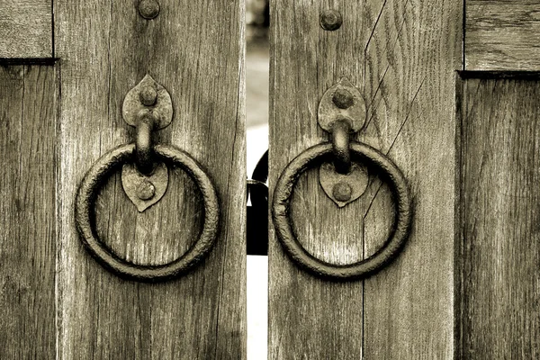 Ancient wooden gate with door knocker rings — Stock Photo, Image