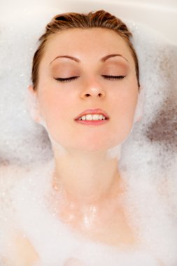 Woman is relaxing in a bathtub clipart