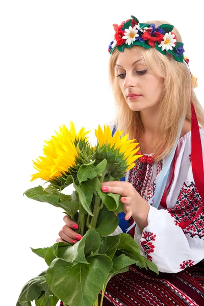 Mulher usa vestido ucraniano está segurando um girassol — Fotografia de Stock