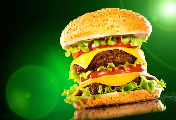 Tasty hamburger and french fries on a dark — Stock Photo, Image