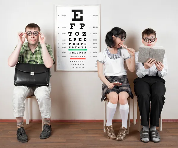 Tres personas con gafas en un consultorio del médico —  Fotos de Stock