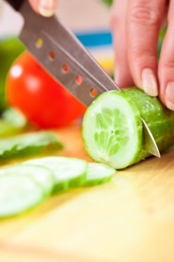 Woman's hands cutting vegetables clipart