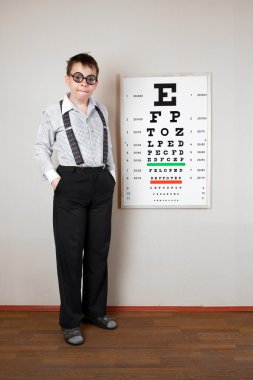 Person wearing spectacles in an office at the doctor clipart