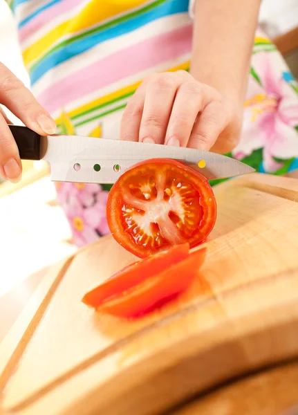 Mains de femme coupant la tomate — Photo
