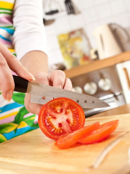 Женские руки режут помидоры — стоковое фото