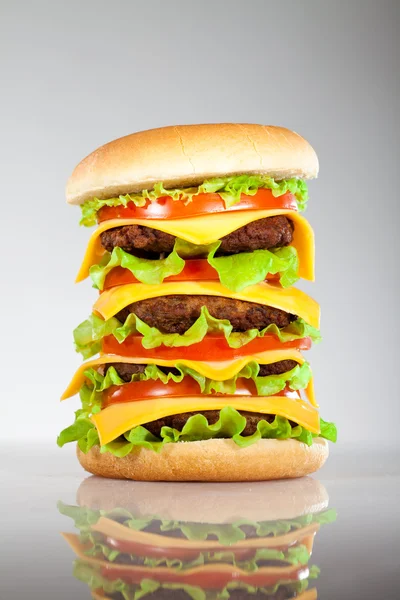 Tasty and appetizing hamburger on a grey — Stock Photo, Image