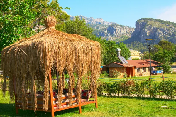 Summerhouse covered straw and tall mountains. — Stock Photo, Image