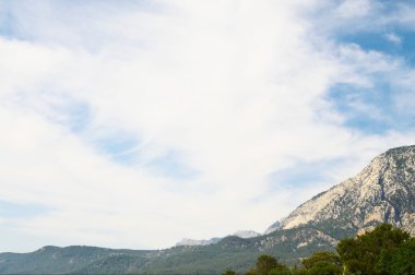 Wonderful mountains and white clouds on the blue sky. clipart