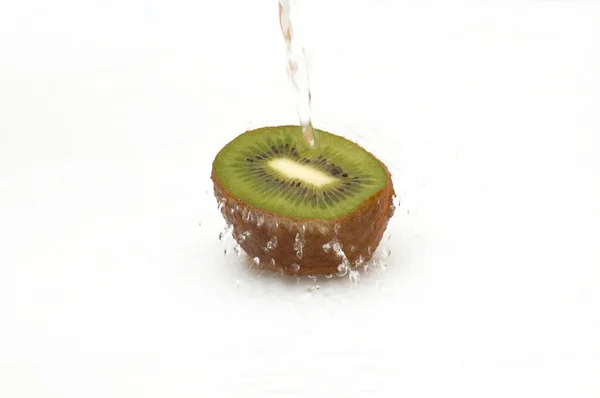Hälften av shaggy, saftig kiwi i strömmande vatten. — Stockfoto