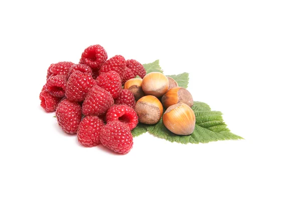 Juicy raspberries and nuts on a white. — Stock Photo, Image