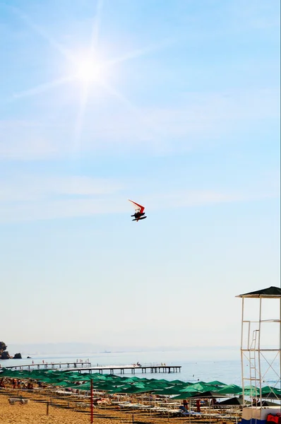 Soleil amusant et deltaplane motorisé au-dessus de la plage . — Photo